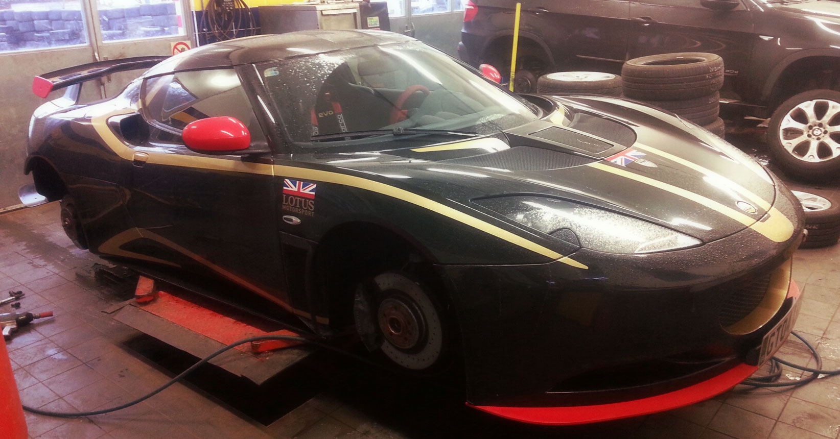 Lotus Evora S se sundanými koly na zvedáku v pneuservisu